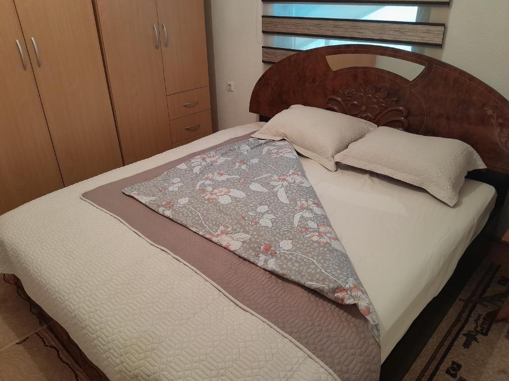 Bett mit einem Kopfteil aus Holz und einer Decke darauf in der Unterkunft Apartman Begić in Travnik