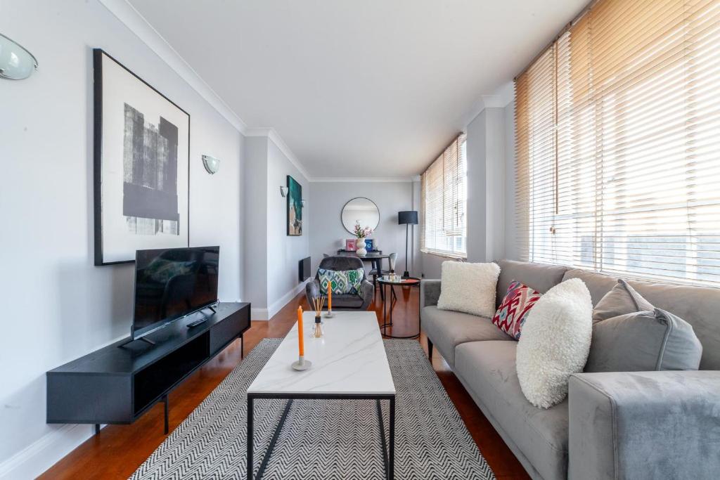 a living room with a couch and a tv at Cosy Apartment Steps From London Eye in London