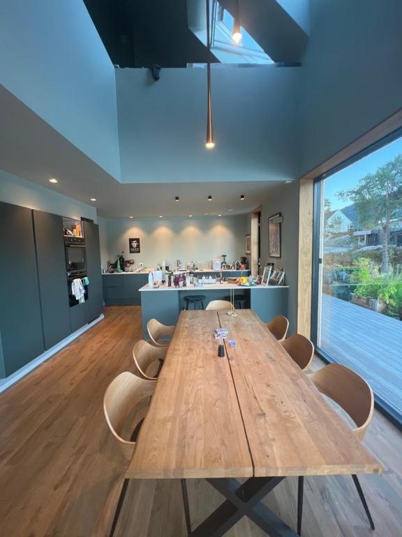 a dining room with a wooden table and chairs at Modern house by the Fjord in Sandane, Nordfjord. in Sandane