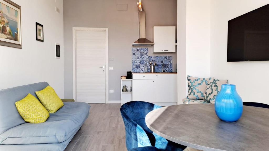 ein Wohnzimmer mit einem blauen Sofa und einem Tisch in der Unterkunft Le Case di Ale in Salerno