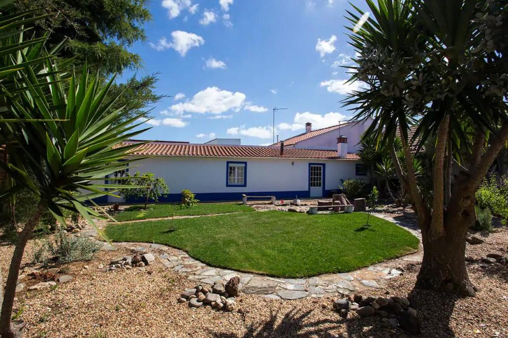 a garden in front of a house with palm trees at Casa da Luz in Longueira