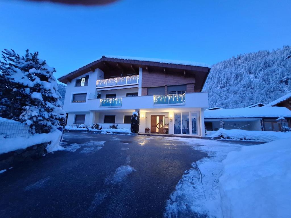 a hotel in the snow at night at Ferienwohnungen Pollhammer in Sankt Gallenkirch