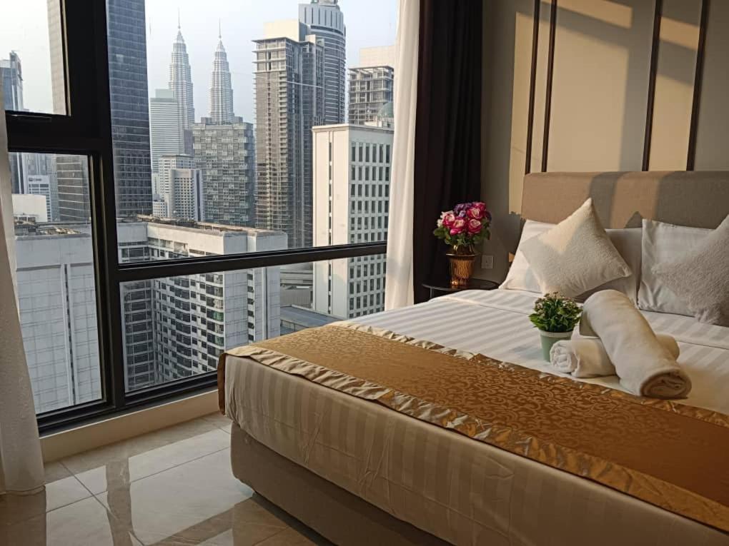 a bed in a room with a view of a city at Axon Serviced Suites in Kuala Lumpur
