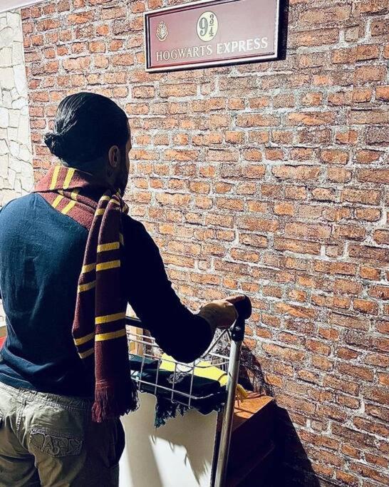 une personne se tient à côté d'un mur de briques dans l'établissement La chambre des secrets Perougien, à Pérouges