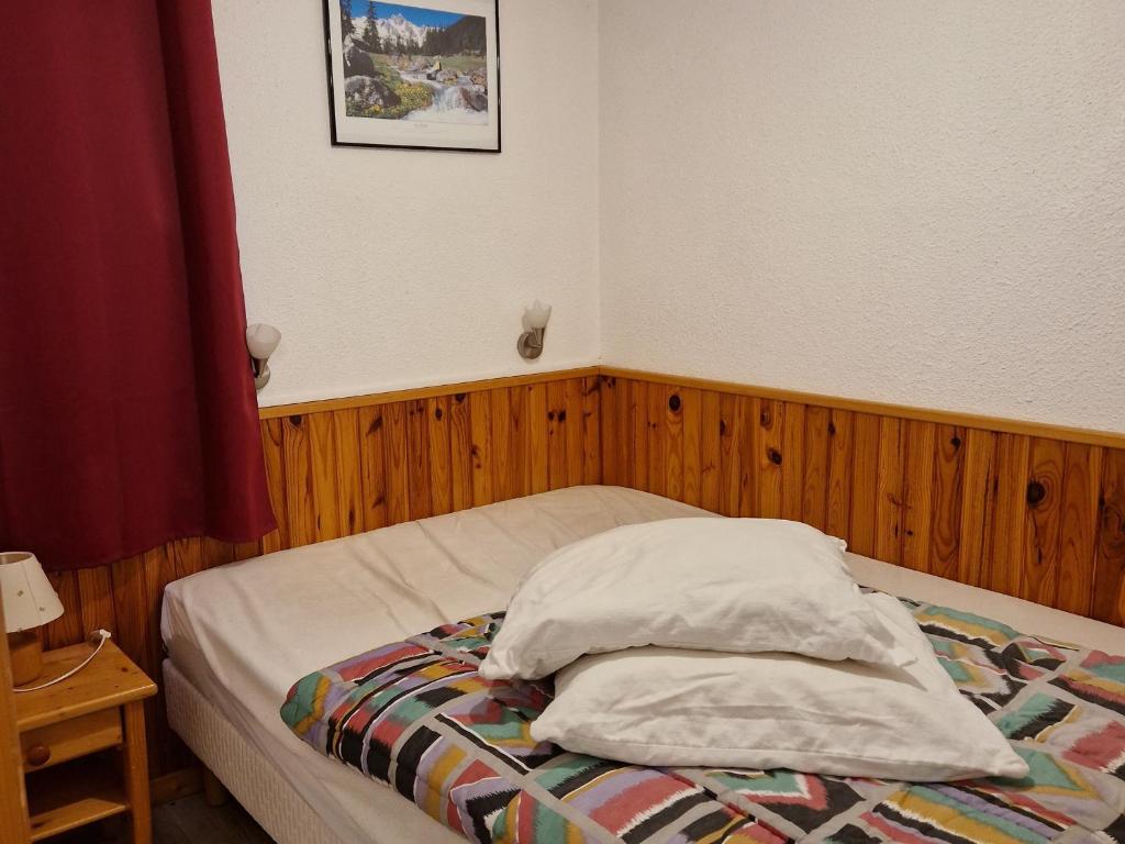 a bedroom with a bed with two pillows on it at Appartement La Plagne Montalbert , 2 pièces, 4 personnes - FR-1-755-4 in Aime-La Plagne