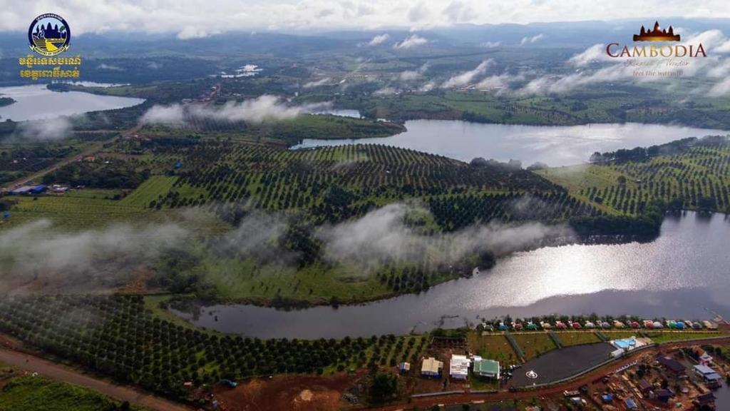 an aerial view of a lake with trees and clouds at Kravanh Camping Cardamom Mountain in Véal Vêng