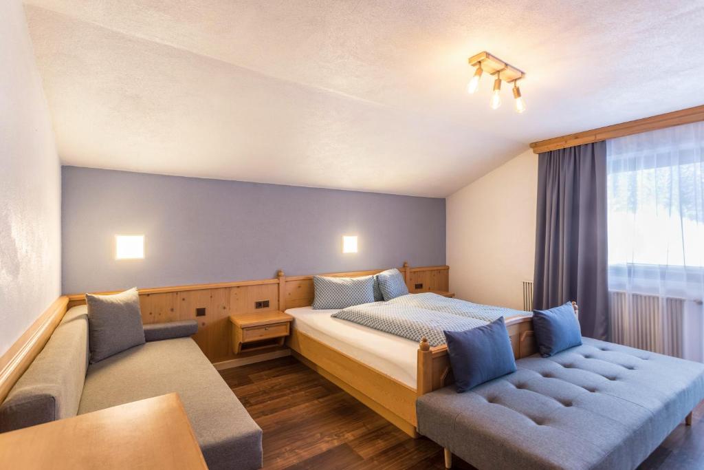 ein Hotelzimmer mit einem Bett und einem Sofa in der Unterkunft Schwüwong - Apartment 01 in Kelchsau