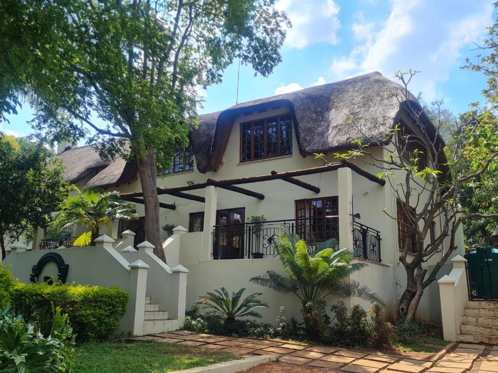 a house with a thatched roof at 60 on Monica, 6 Bedroom Lesedi Lodge, Hartbeespoort in Hartbeespoort