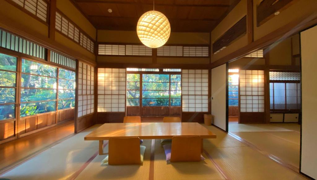 een kamer met een tafel en twee krukken en ramen bij 葉山 - Nowhere but Hayama in Hayama