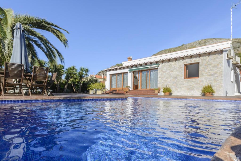 una villa con piscina di fronte a una casa di Casa Lea ad Alcalalí