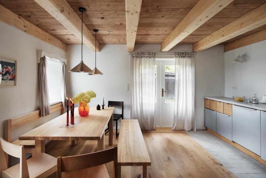 een keuken en eetkamer met een houten tafel en stoelen bij Chaloupka Dvě Sestry in Kořenov