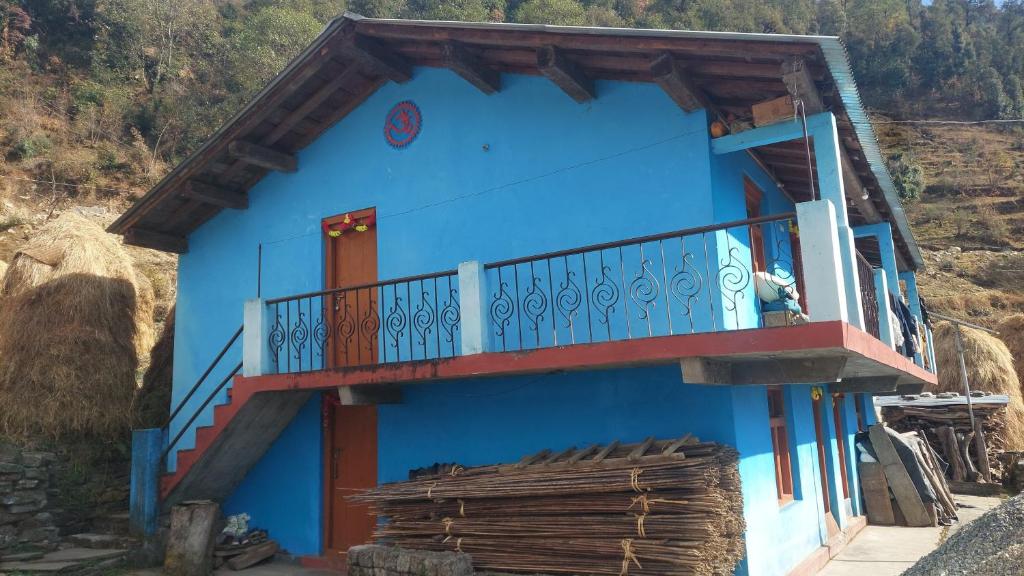 Casa azul con balcón en una montaña en Rashi Home Stay Khati, en Bāgeshwar