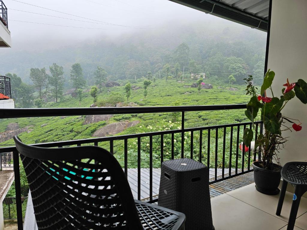 a balcony with a chair and a view of a mountain at Tea Dale - All rooms with Tea Estate view in Munnar