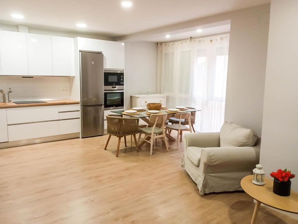 a kitchen and living room with a table and a couch at Center Granada Apartament Elegant in Granada