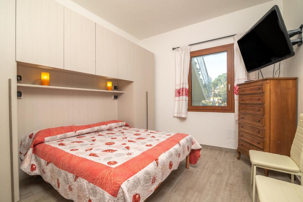 Appartamento Bellavista في Telti: غرفة نوم بسرير وتلفزيون بشاشة مسطحة