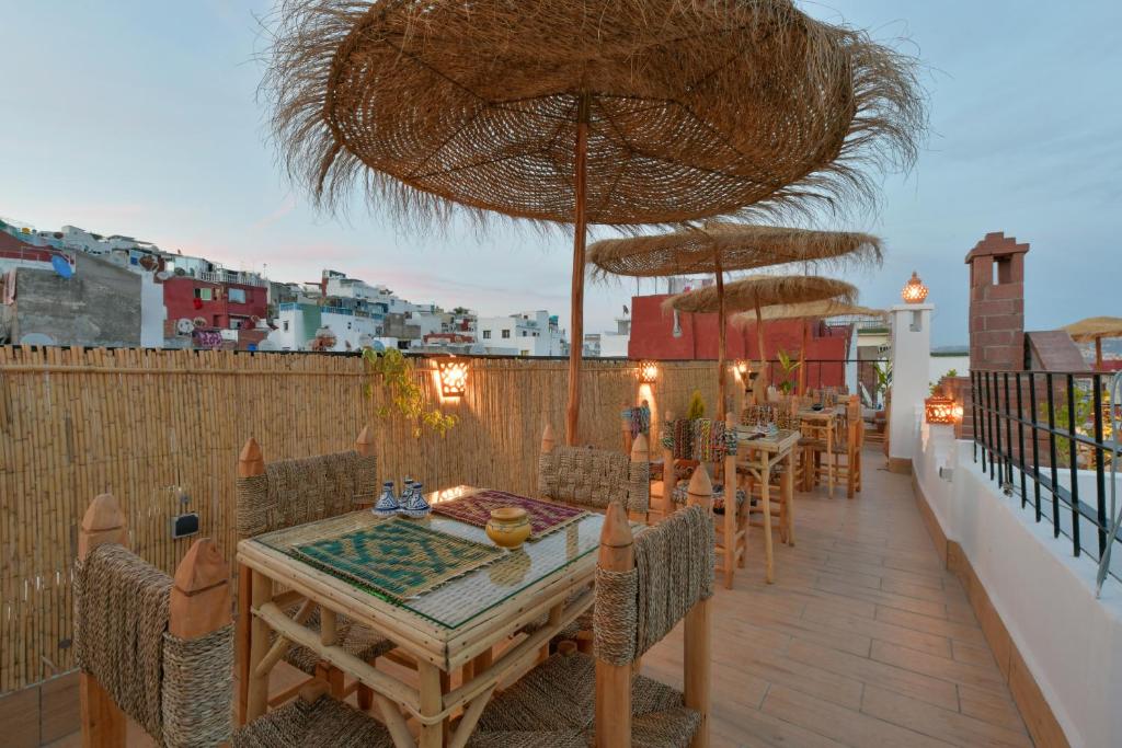 a patio with tables and umbrellas on a balcony at RIAD AMR in Tangier