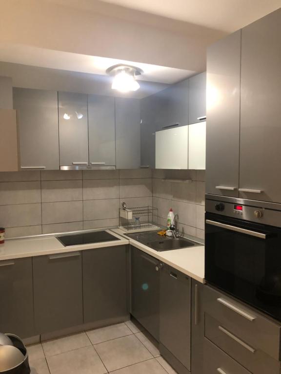 uma cozinha com armários brancos e um aparelho preto em Empire Apartments em Skopje