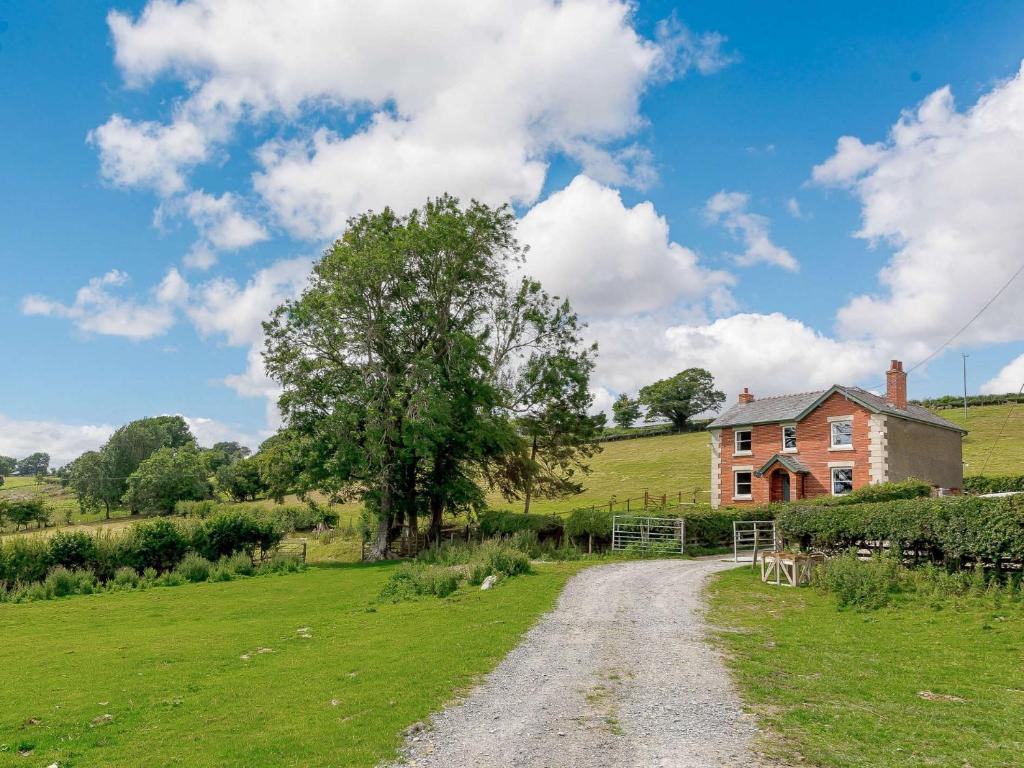 a dirt road leading to a house in a field at 4 Bed in Welshpool 89012 in Llanfair Caereinion