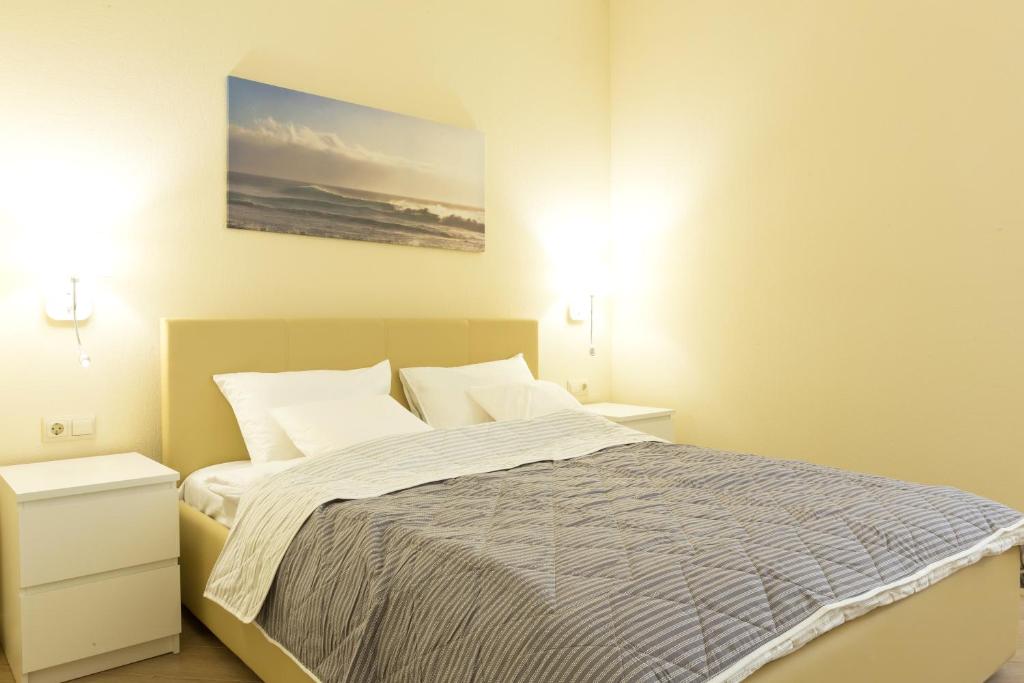 アクタウにあるMIRAMAR Apart Hotel & SPAのベッドルーム1室(ベッド1台、ナイトスタンド2台、ランプ2つ付)