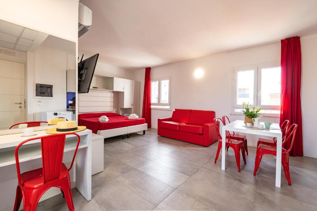 ミザーノ・アドリアーティコにあるRabbit Homeのリビングルーム(赤い椅子、テーブル付)