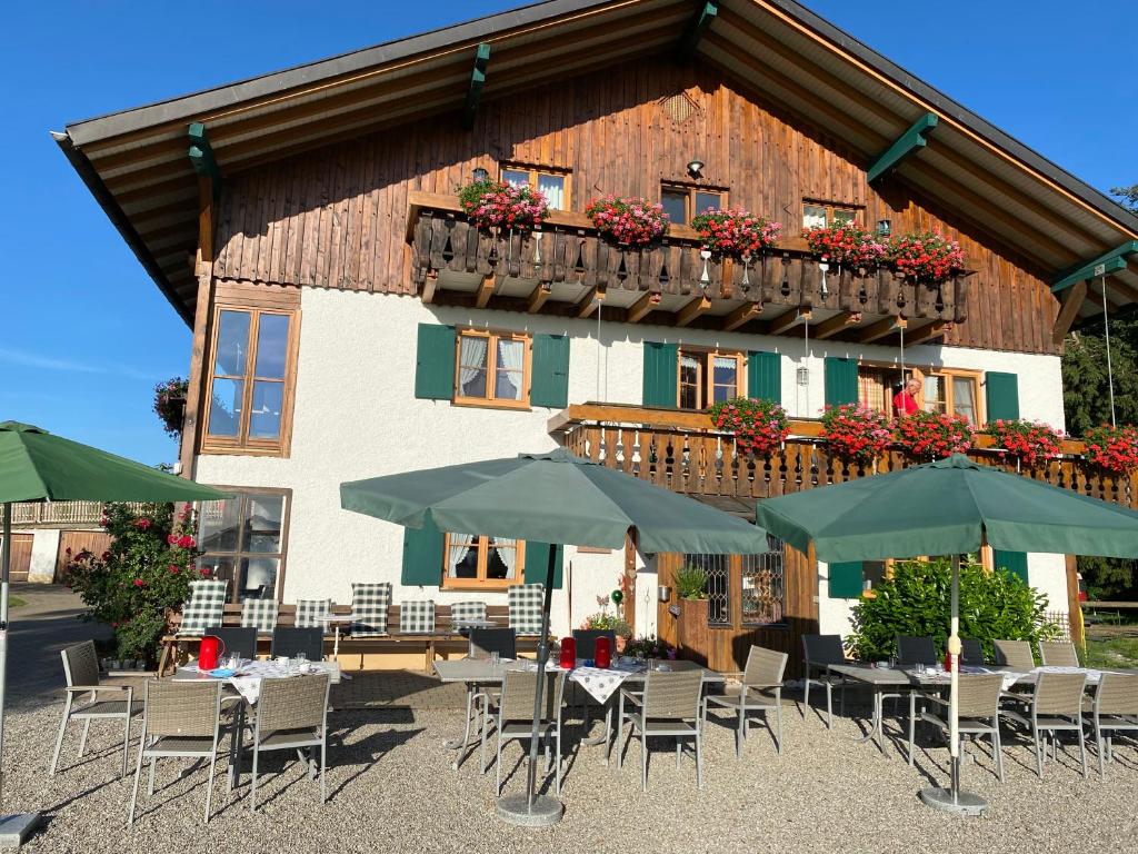 un edificio con mesas, sillas y sombrillas en Gmeinder's Landhaus, en Immenstadt im Allgäu