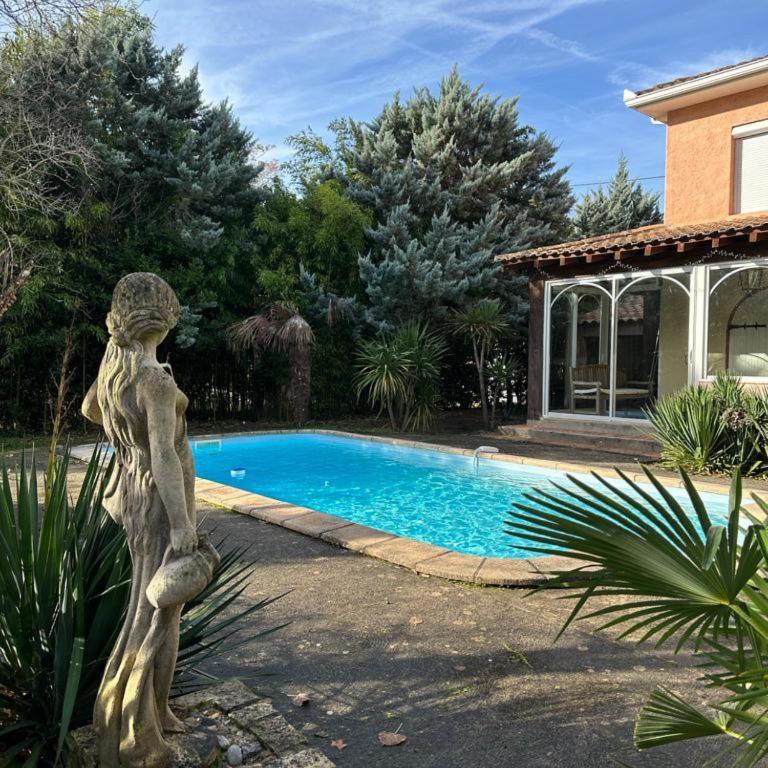une statue d'une femme debout à côté d'une piscine dans l'établissement Ty Calon Lan, à Montazels