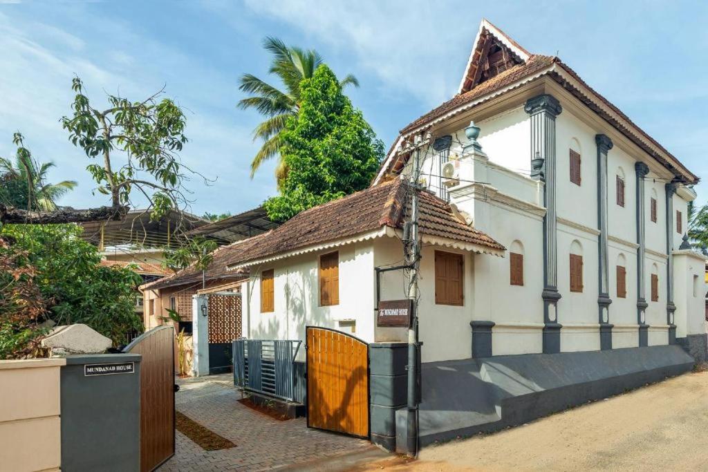 a white house with a gate in front of it at The Mundanad House in Trivandrum