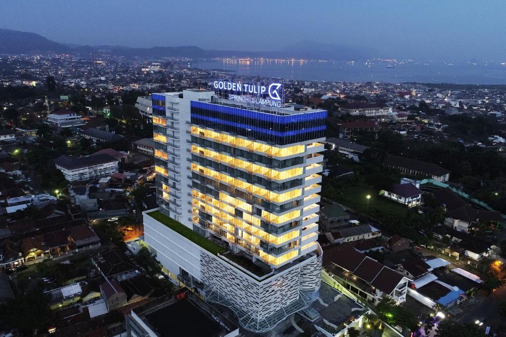 een hoog gebouw met een bord erop bij Golden Tulip Springhill Lampung in Bandar Lampung