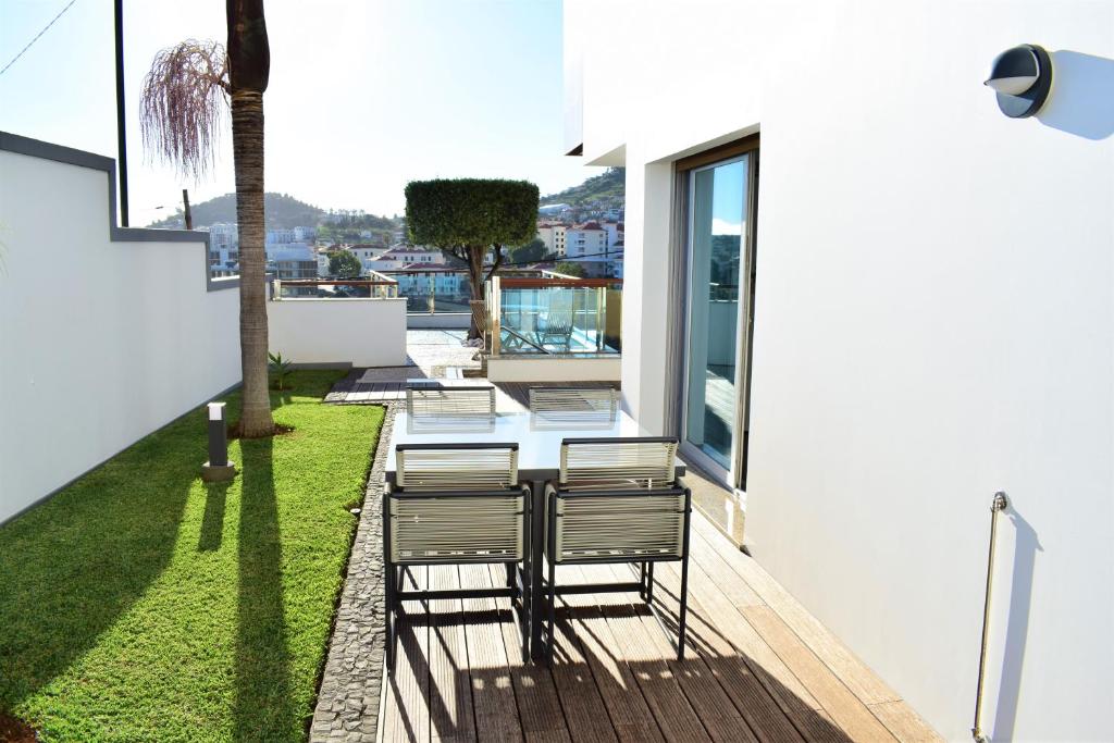 Un patio con sillas y una mesa en el balcón. en Moradia Vista Atlântico en Funchal