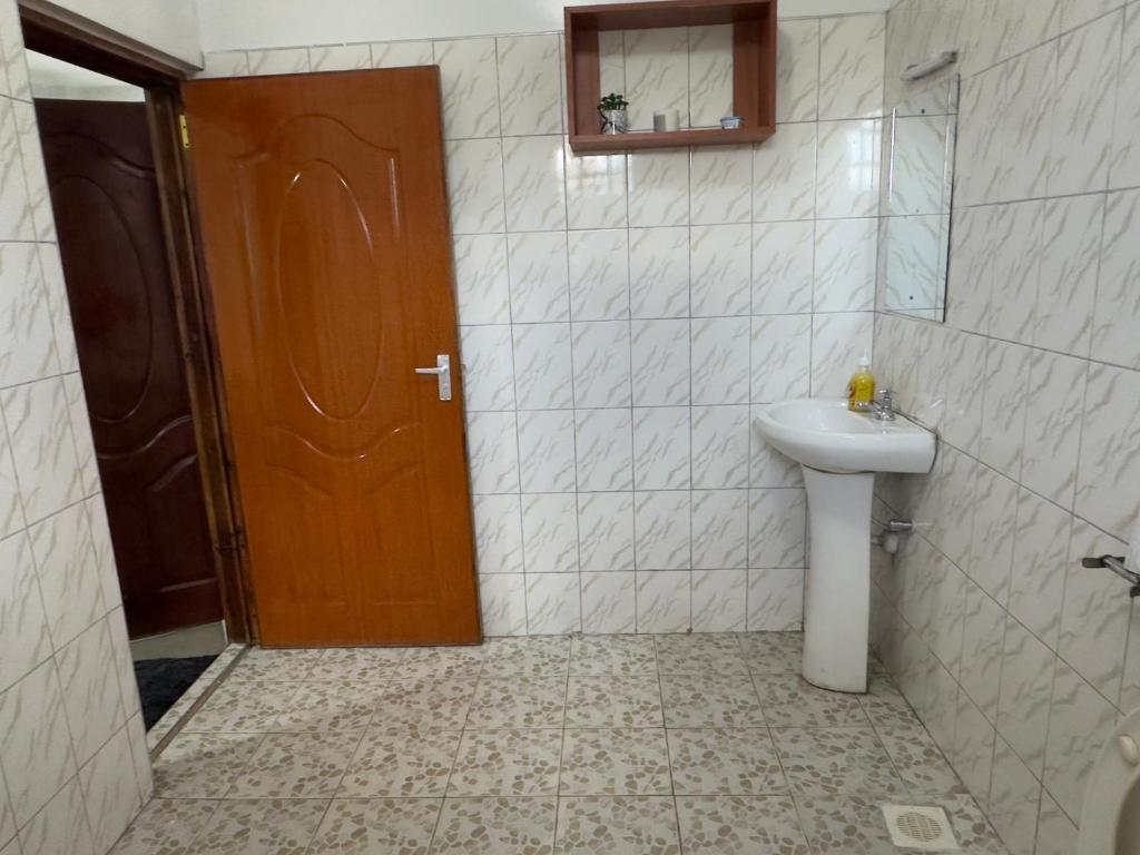 a bathroom with a sink and a toilet and a door at Serene 2 Bedrooms Apartment in Kericho