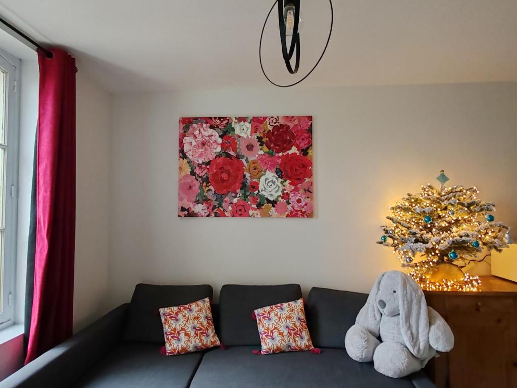 uma sala de estar com um sofá e uma árvore de Natal em La Maison des Magnolias em Trouville-sur-Mer