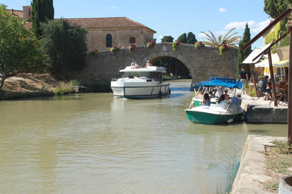 deux bateaux sont amarrés dans une rivière près d'un pont dans l'établissement La Casa d'Anthony, à Ginestas