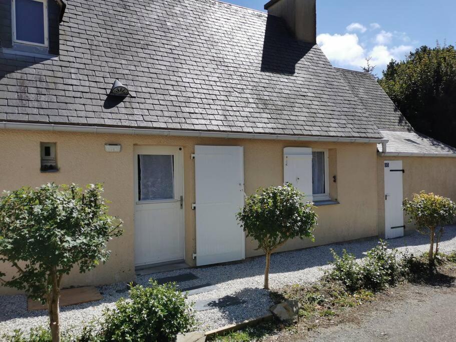 ein Haus mit zwei weißen Garagentüren und zwei Bäumen in der Unterkunft The place to be in Barneville-Carteret