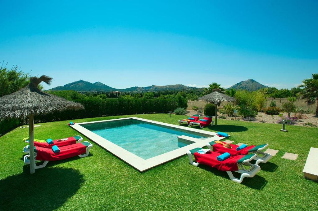 a group of lawn chairs and a swimming pool at Villa Figueral by Villa Plus in Alcudia