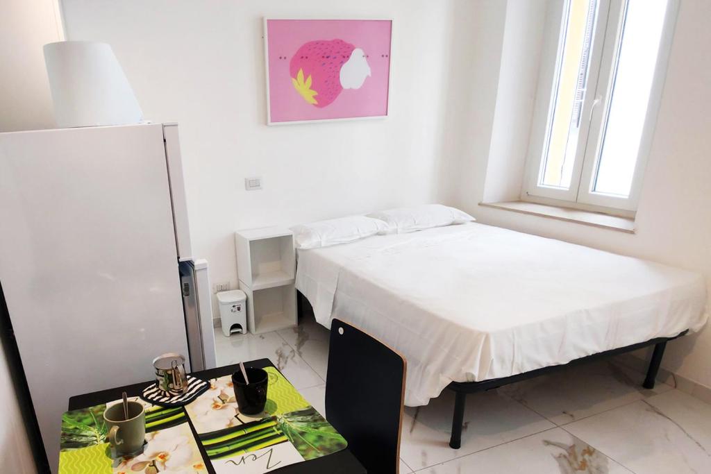 a bedroom with two beds and a desk with a table at Maestri 7 in Parma
