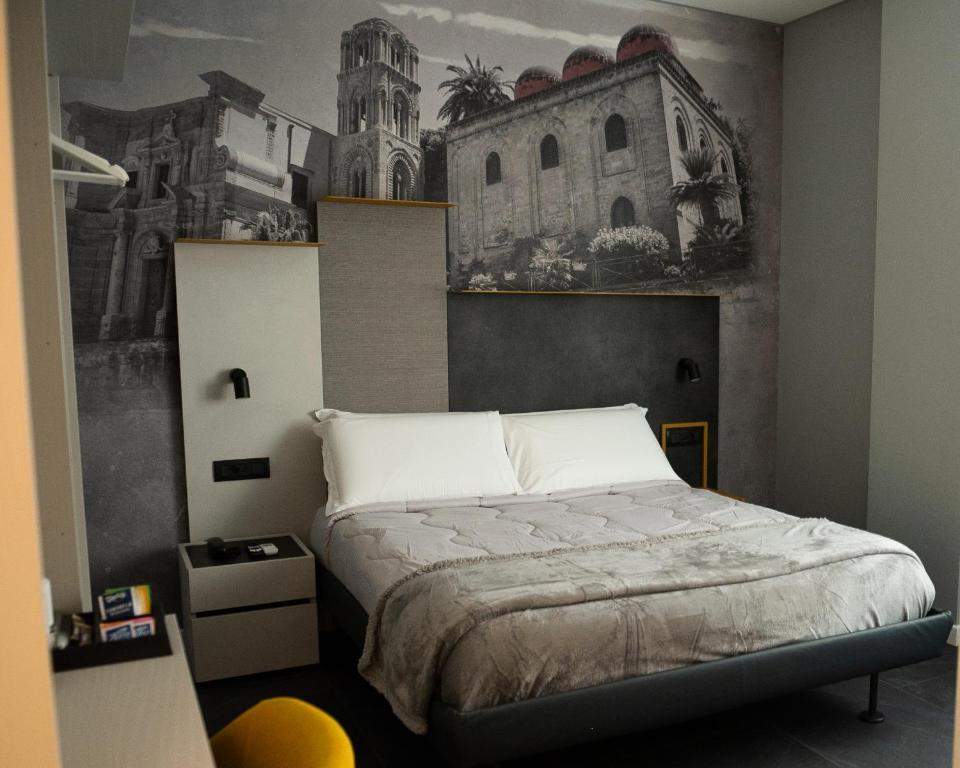 a bedroom with a bed with a painting on the wall at Alma Hotel in Palermo