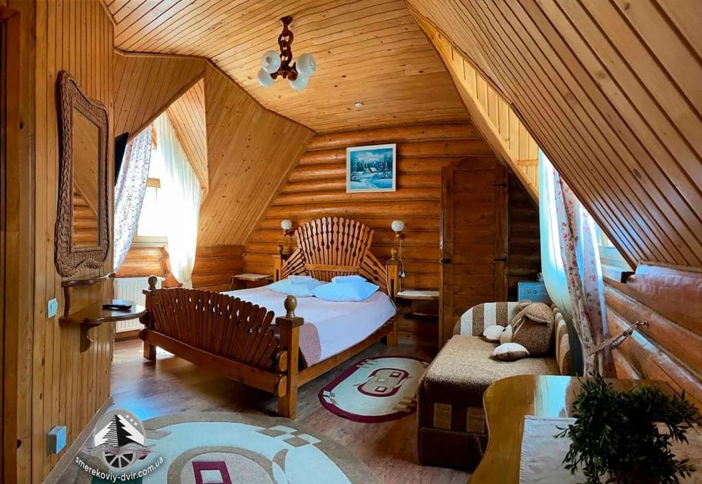 a bedroom with a bed in a log cabin at Smerekovyi Dvir in Zhdenievo