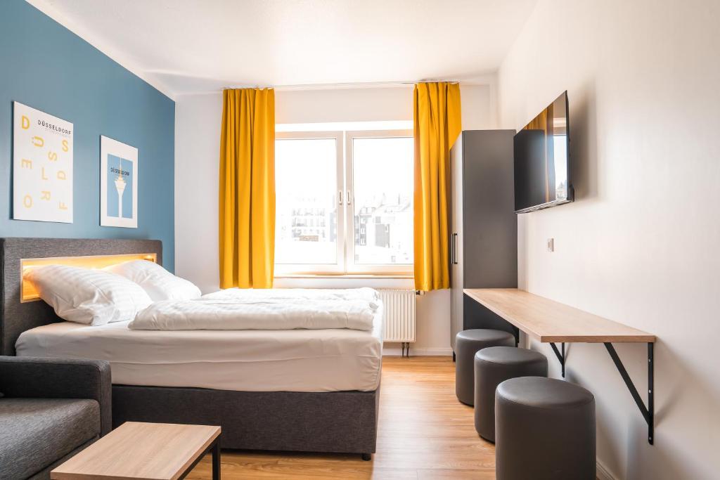 a small hotel room with a bed and a couch at Antares Apartments in Düsseldorf