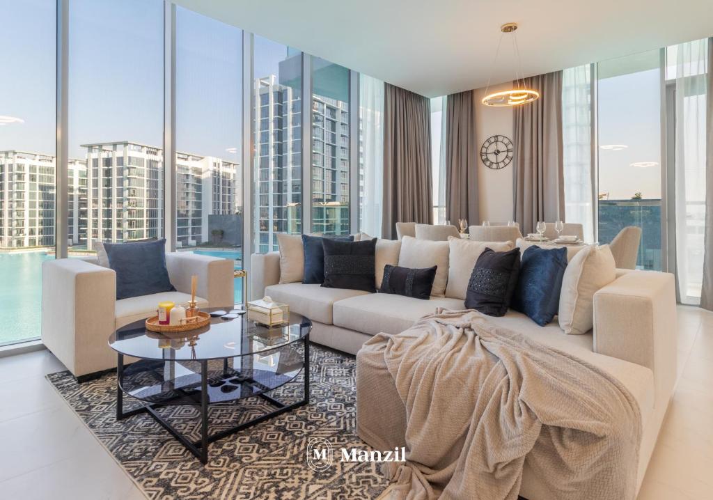 een woonkamer met een bank en een tafel bij Manzil - 3BR + Maid in District One with Burj View in Dubai