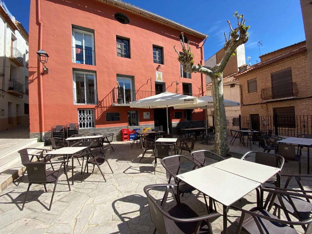 un patio avec des tables et des chaises en face d'un bâtiment dans l'établissement El Albergue Cirat, à Cirat