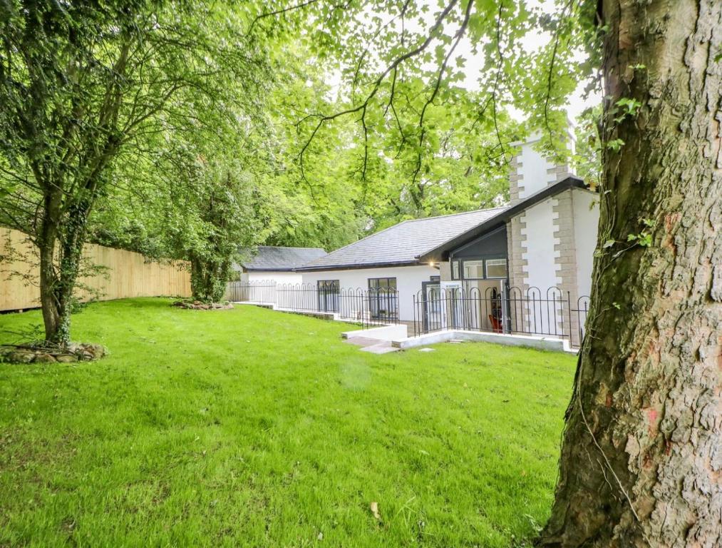 a yard with a white house with a fence at NEW Luxury family/dog-friendly countryside retreat in Kirkby Thore