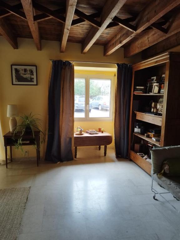 uma sala de estar com uma mesa e uma janela em "A la ferme moderne" - campagne rennaise em Chantepie
