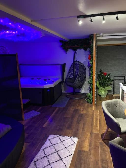 een paarse kamer met een bank en een stoel bij Le 36/Espace bien-être privatif in Bellevaux