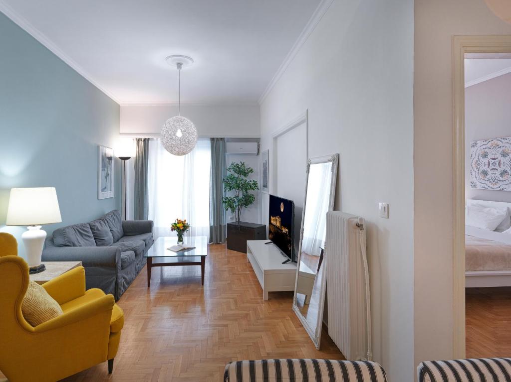 een woonkamer met een bank en een bed bij GORGEOUS center Apartment in Athene