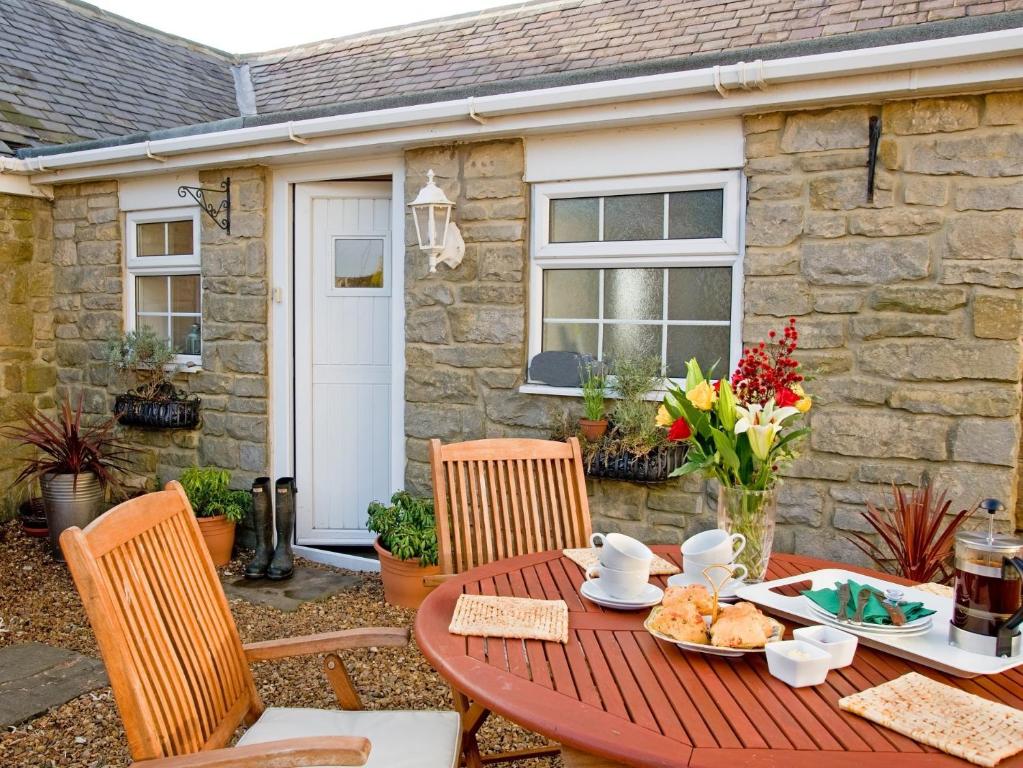 a red table and chairs in front of a house at 2 Bed in Nr Gibside CN080 in Whickham