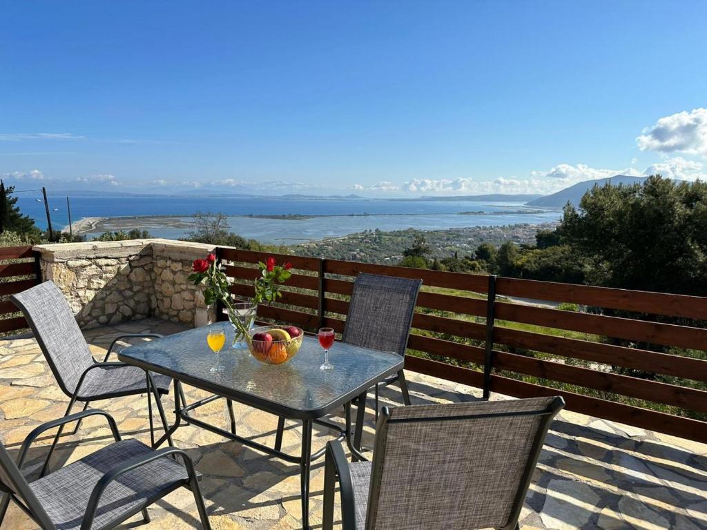 una mesa y sillas en un patio con vistas en Eris Villa - Amazing view In Lefkada, en Lefkada