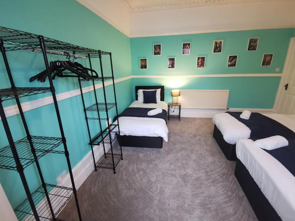 2 Etagenbetten in einem Zimmer mit grünen Wänden in der Unterkunft Spacious and Comfy 4 Bed House, Free Parking, Wifi in Birkenhead