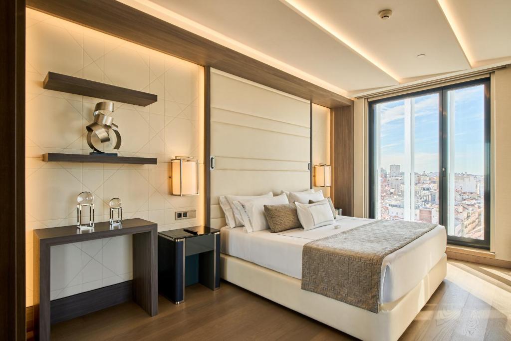 a bedroom with a bed and a large window at VP Plaza España Design in Madrid