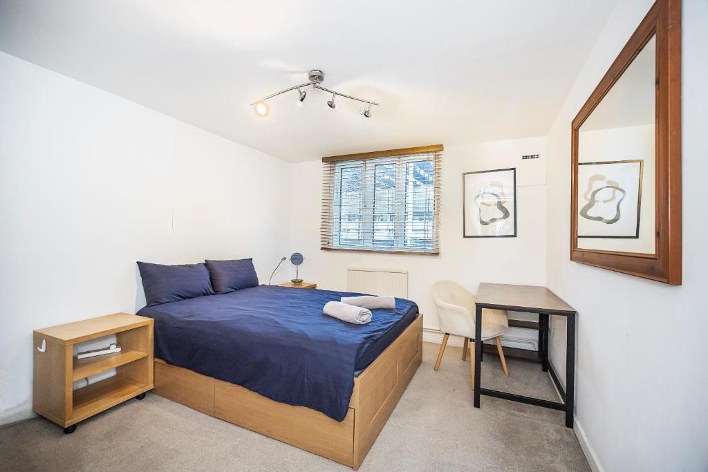 a bedroom with a bed and a table and a mirror at Warm & Cosy Flat in King Cross in London