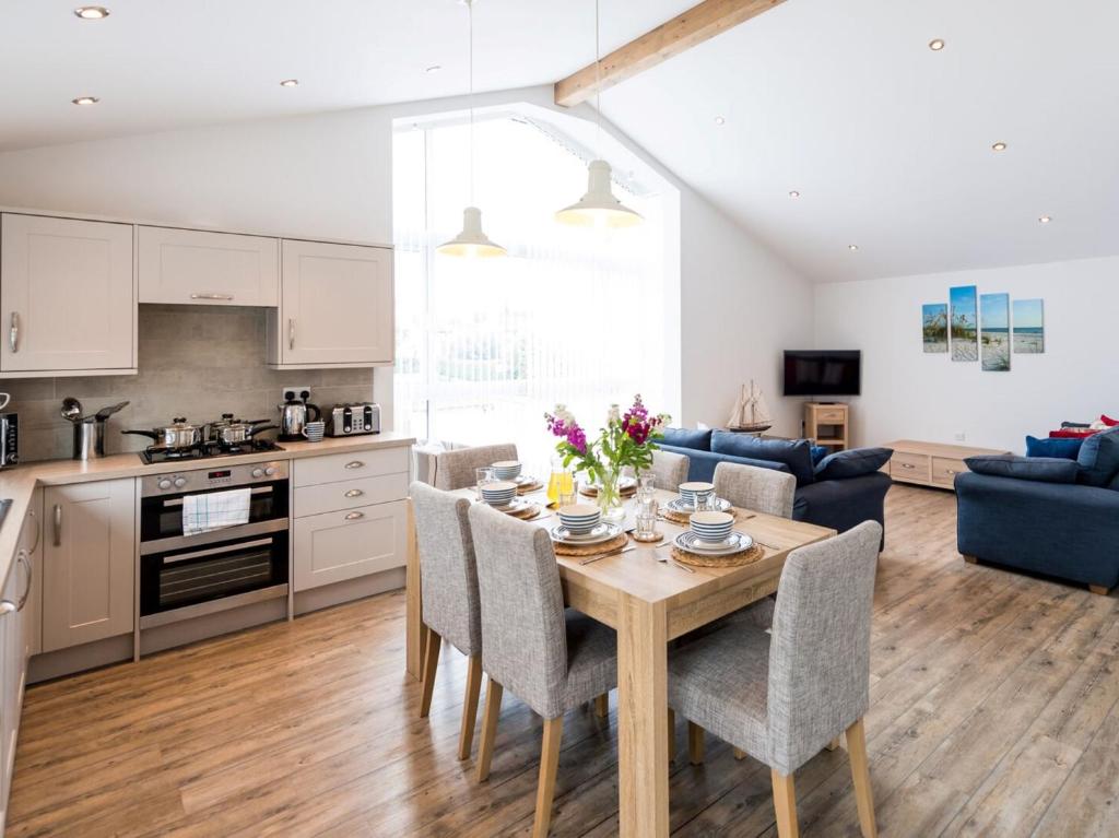 een keuken en een woonkamer met een houten tafel en stoelen bij 3 Bed in Westward Ho 64410 in Northam